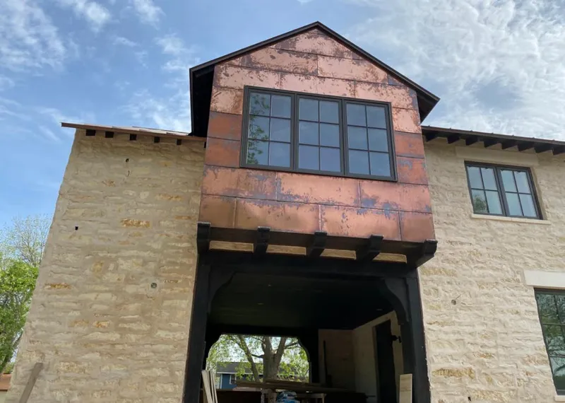 Copper metal panel facade on a stone building for Skylight Installation in Waimea